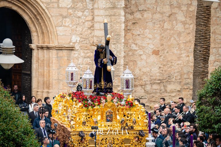 Nuestro Padre Jesús Nazareno de Ciudad Real junto a la banda en las puertas de la iglesia, en una imagen a color tomada por Ikonox durante el Domingo de Pasión.