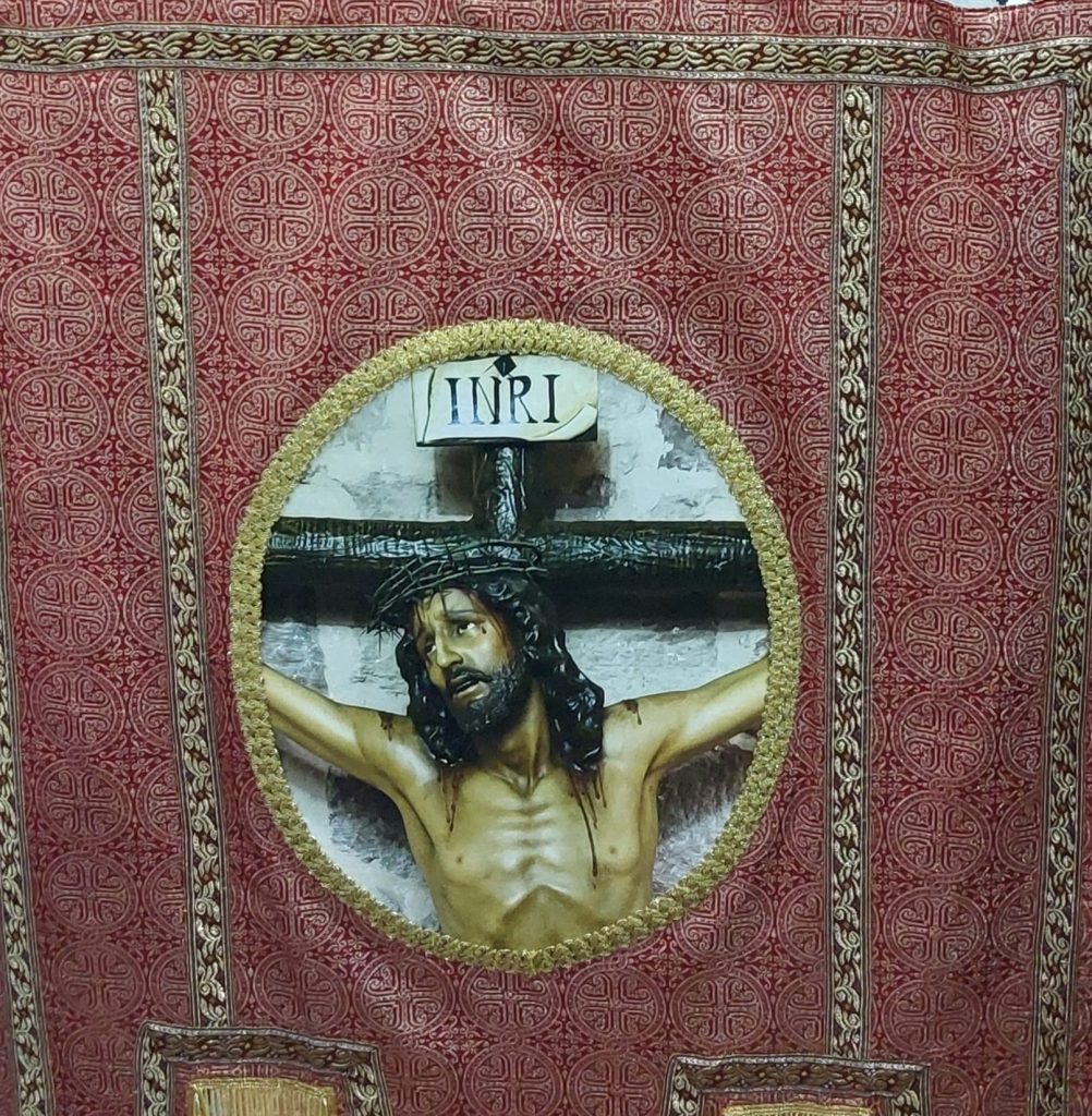 Detalle del estandarte restaurado de la Hermandad del Cristo de la Expiación con la imagen del INRI, fotografía realizada por Ikonox.